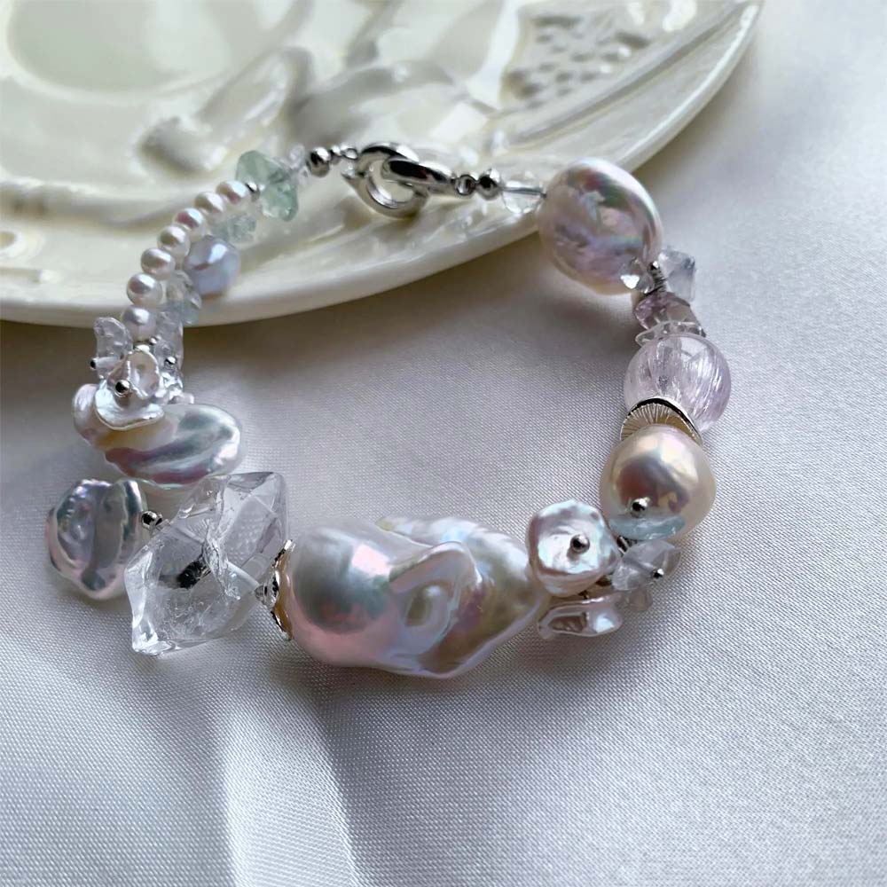 Chunky LiraGee bracelet featuring large iridescent freshwater baroque pearls, raw clear crystal chunks, and carved pearl blossoms.