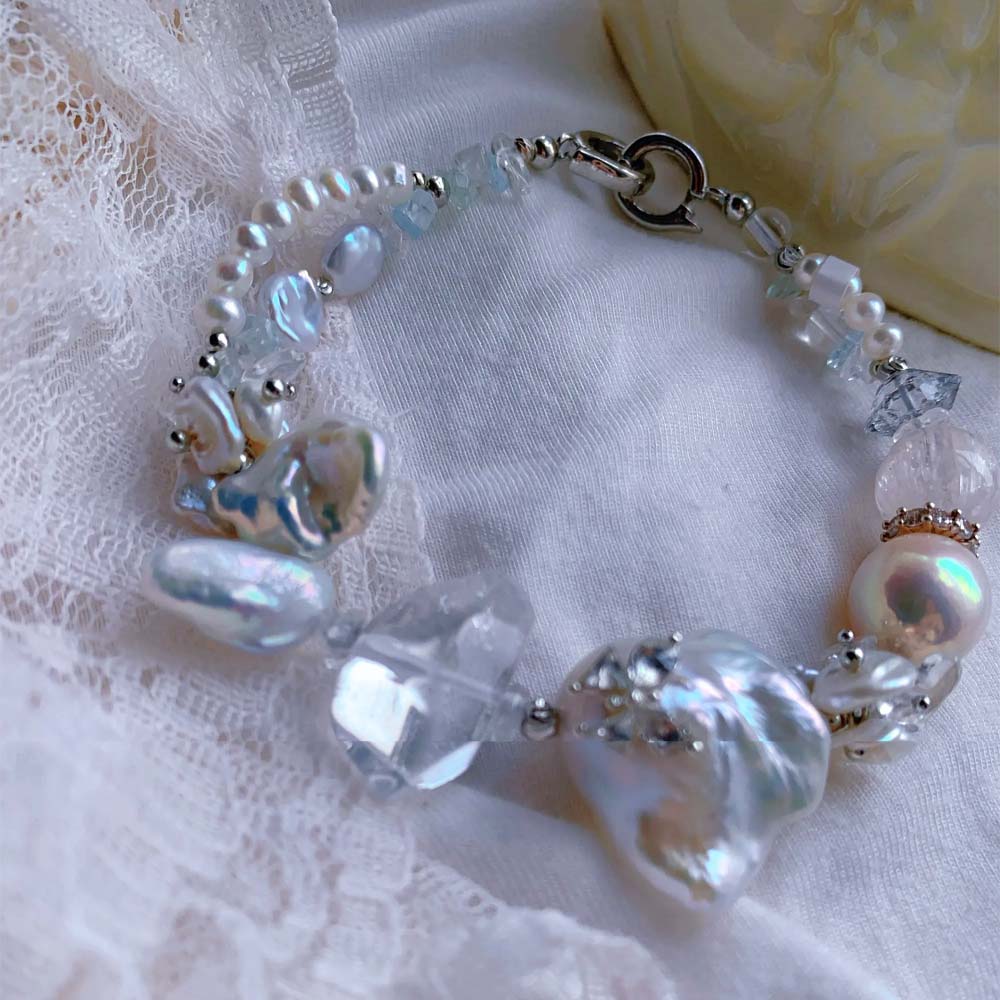 Freshwater baroque pearl bracelet featuring a central iridescent pearl decorated with a small sparkling butterfly accent.