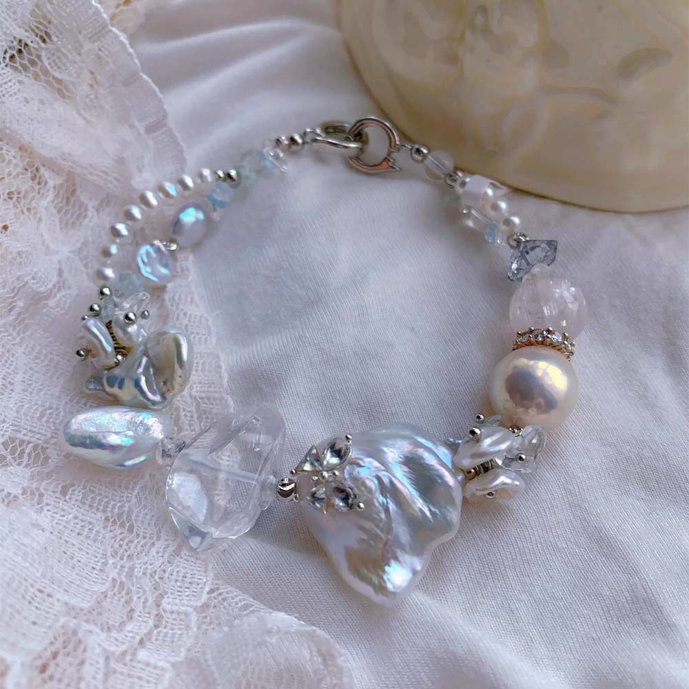 Freshwater baroque pearl bracelet featuring a central iridescent pearl decorated with a small sparkling butterfly accent.