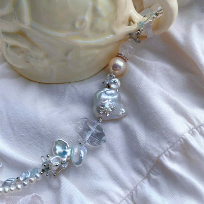 Freshwater baroque pearl bracelet featuring a central iridescent pearl decorated with a small sparkling butterfly accent.