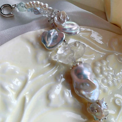 Chunky LiraGee bracelet featuring large iridescent freshwater baroque pearls, raw clear crystal chunks, and carved pearl blossoms.