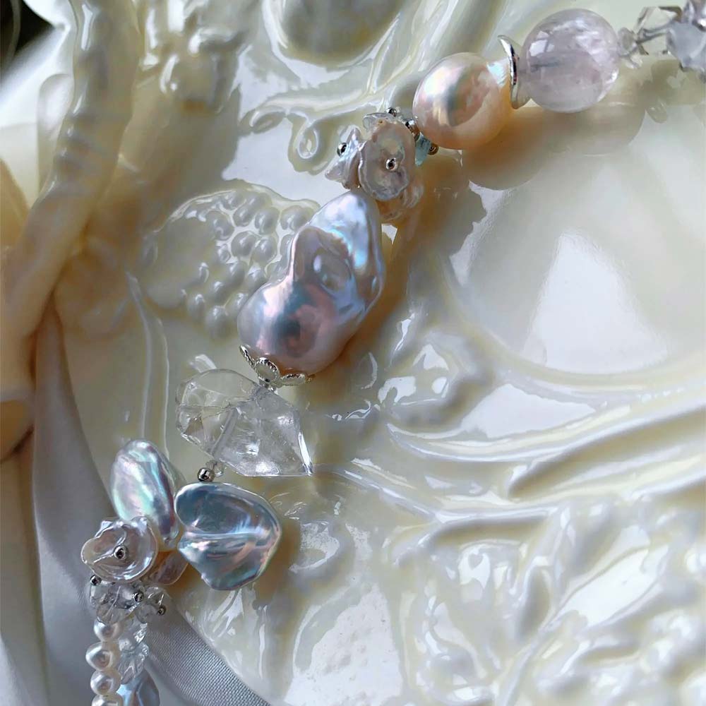 Chunky LiraGee bracelet featuring large iridescent freshwater baroque pearls, raw clear crystal chunks, and carved pearl blossoms.